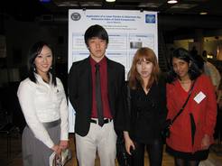 four students posing in front of presentation poster in 2012
