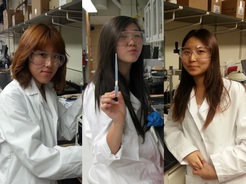 group of 3 female students wearing lab coats and goggles in year 2014