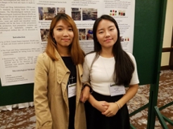 2 female students standing in front of poster presentation in 2017