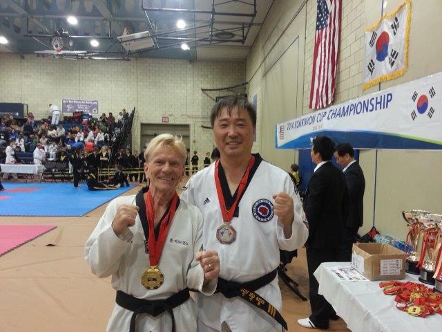 2 men wearing winning medals for the 2014 Kukkiwon Cup Championship