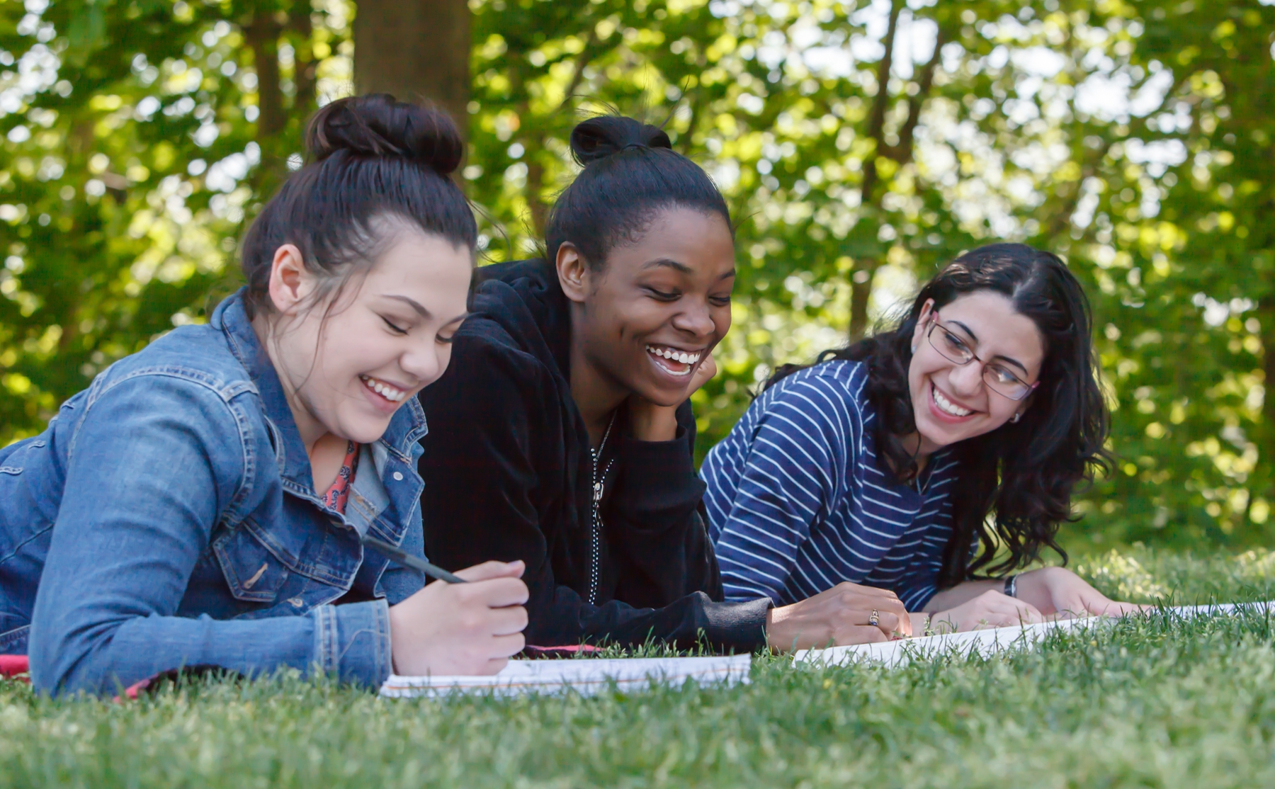 Students on campus smiling, taking notes