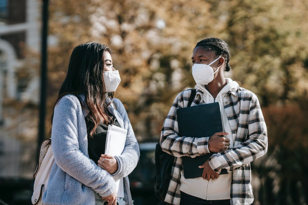 students walking wearing masks and walking on campus