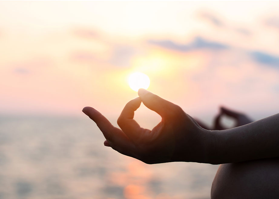Mantra yoga meditation, spiritual mental health practice with silhouette of woman in lotus pose having peaceful mind relaxation on the beach outdoor training with sunset golden hour heavenly sky.