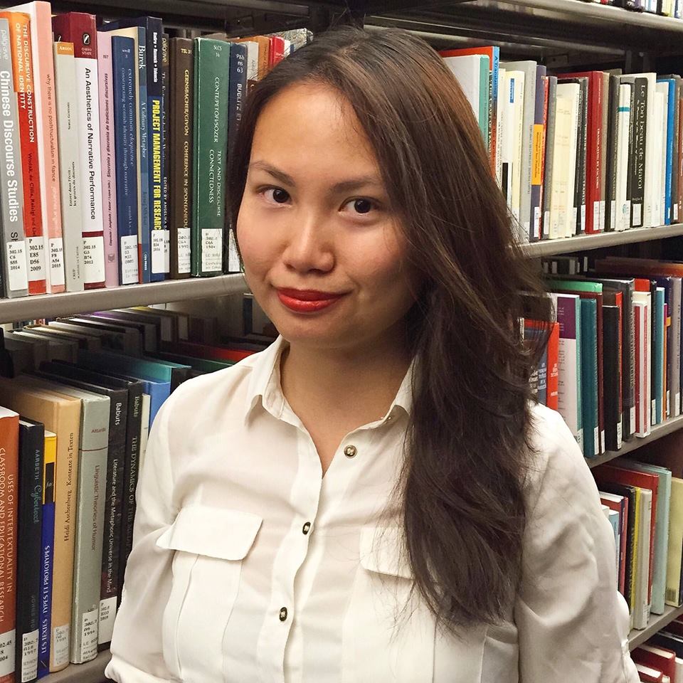Charissa Che in library aisle next to books