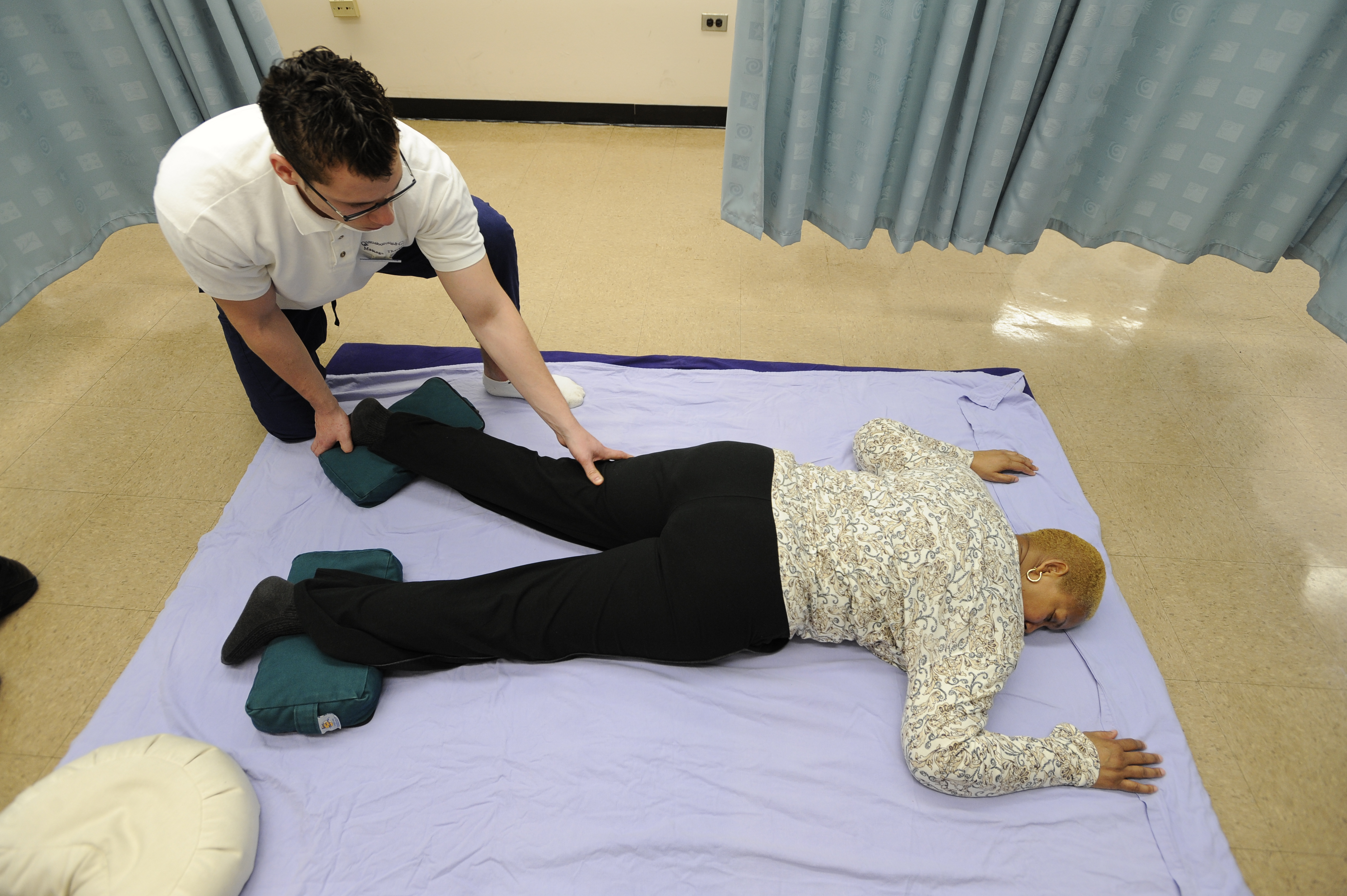Queensborough Massage Therapy Student practices leg massage on manikin