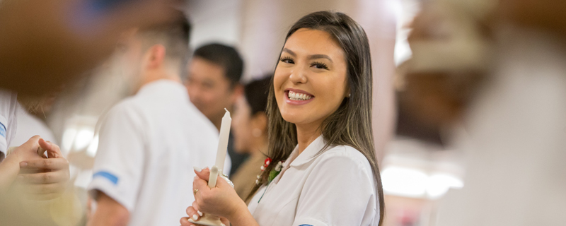 female nursing student smiling during candlelighting ceremony