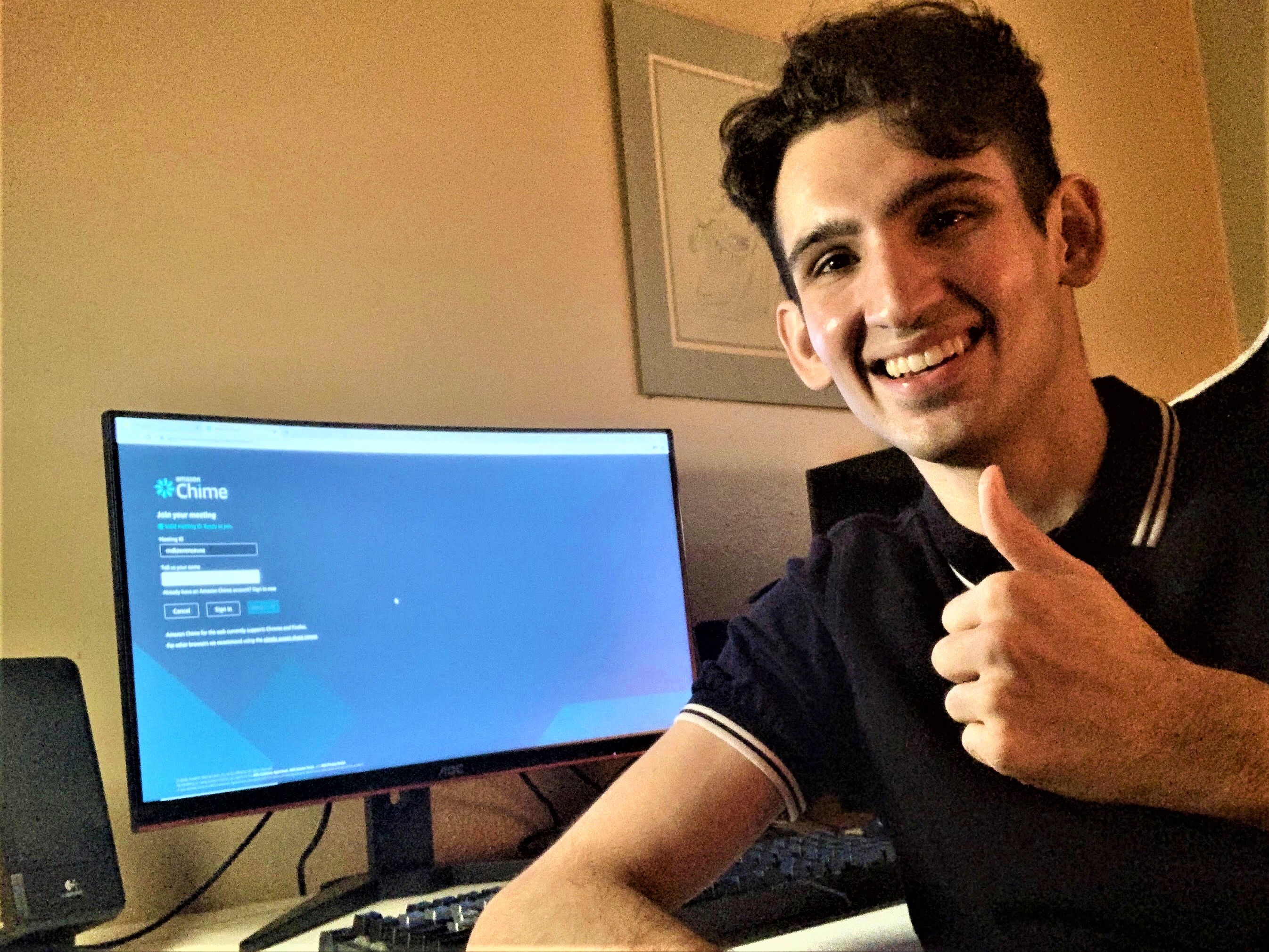 student Jason Bhimani smiling and giving thumbs up near computer